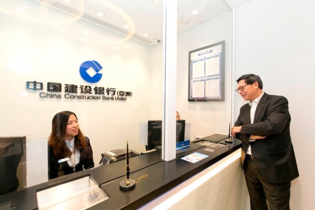 金管局总裁陈德霖先生与中国建设银行的职员交谈